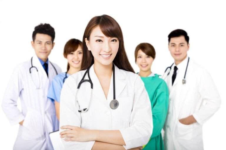 smiling medical team standing together isolated on white
